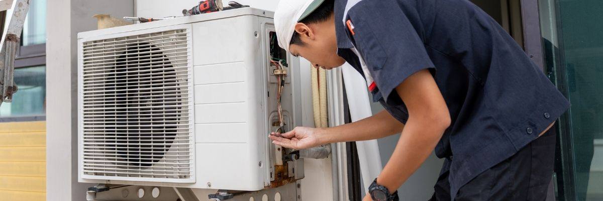 Technician repairing an outdoor air conditioner for a Scarborough home