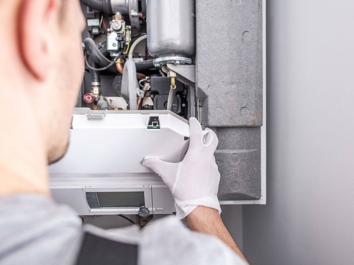 HVAC technician servicing a high efficiency furnace in a Scarborough home